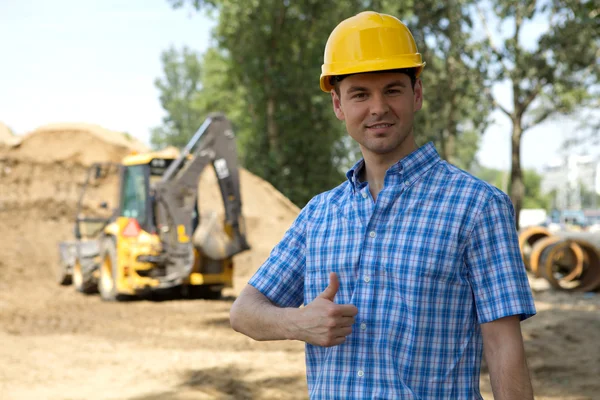 Portrait of architect showing thumbs up sign at construction site