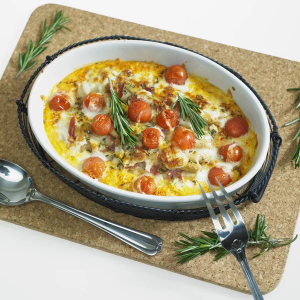 Baked white asparagus with cherry tomatoes on rosemary