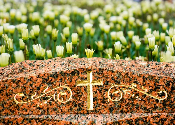 Cross on Gravestone with Flowers