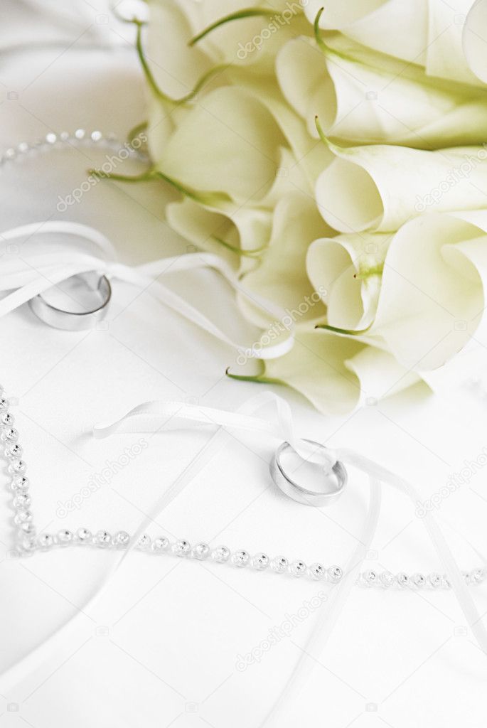 White flowers and wedding rings