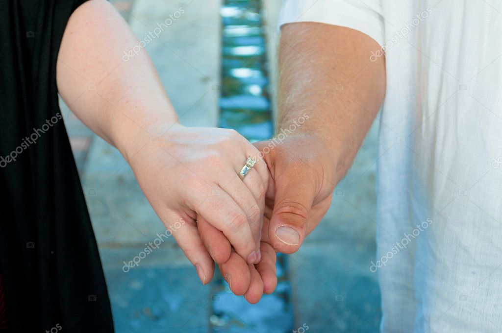 holding hands with wedding ring
