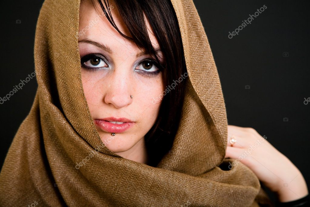 Beautiful teen girl with piercings over dark background