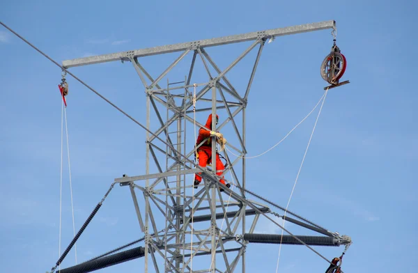 Worker on top of a hydro tower
