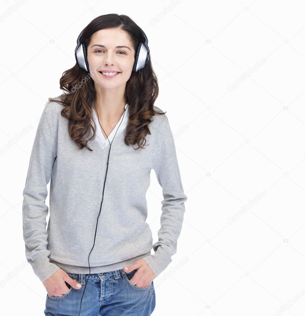 Portrait of a happy young woman wearing headphones over white background