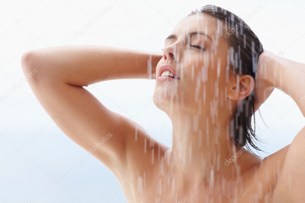 Portrait of a pretty young woman taking a bath at an outdoor shower