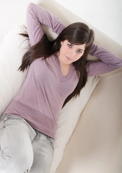 Young woman relaxed lying on couch home interior