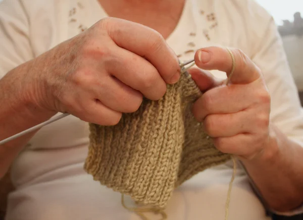 hands of an elderly woman knitting