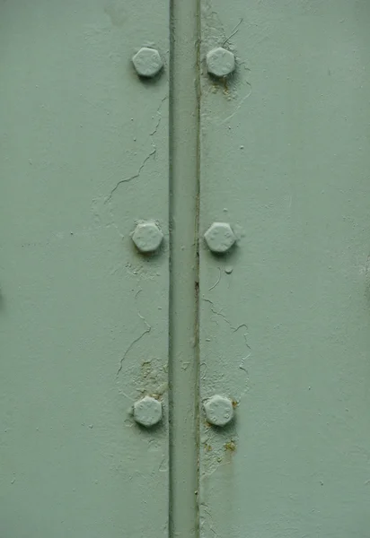Detail of bolts on a mint green metal door