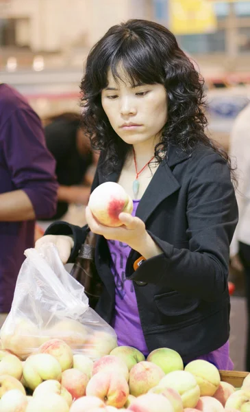Woman buying peaches