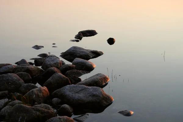 Stones in calm sunset water — Stock Photo #3082926
