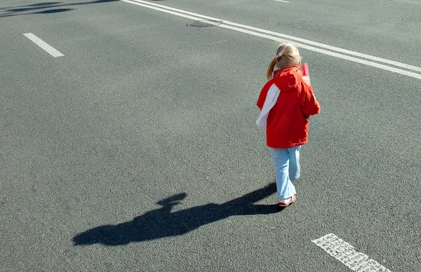 Child running on empty road