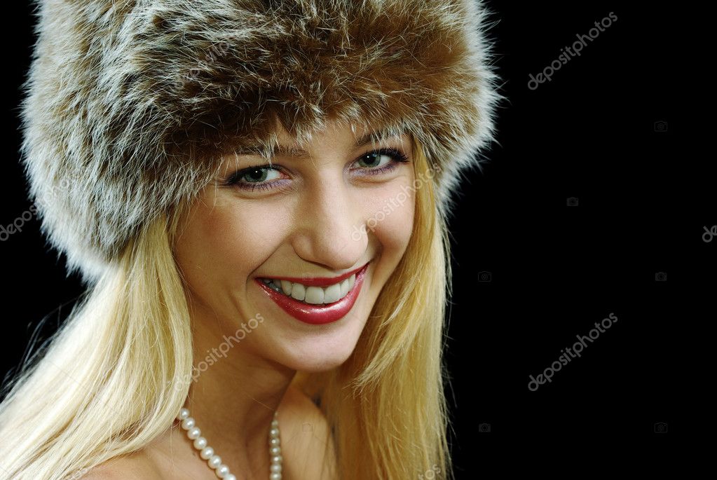 Blonde girl in pearl necklace and fur hat with naked shoulders