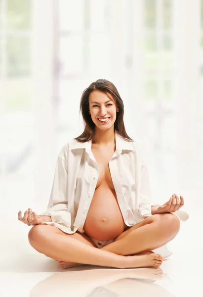Young pregnant woman in state of calm yoga posing by Konrad B k Stock 