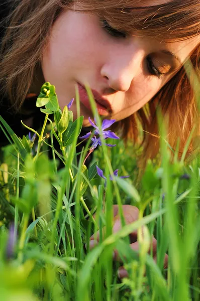 Girl bent over to the flower by Stock Photo