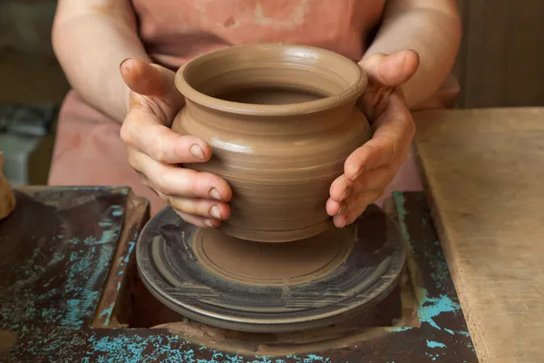 Potter creates a pitcher on a pottery wheel