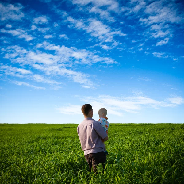 Father and son on green field