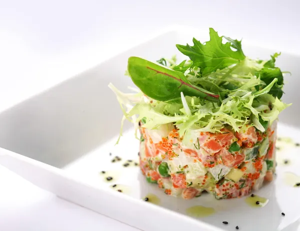 Salad with salmon, caviar and arugula on a white background