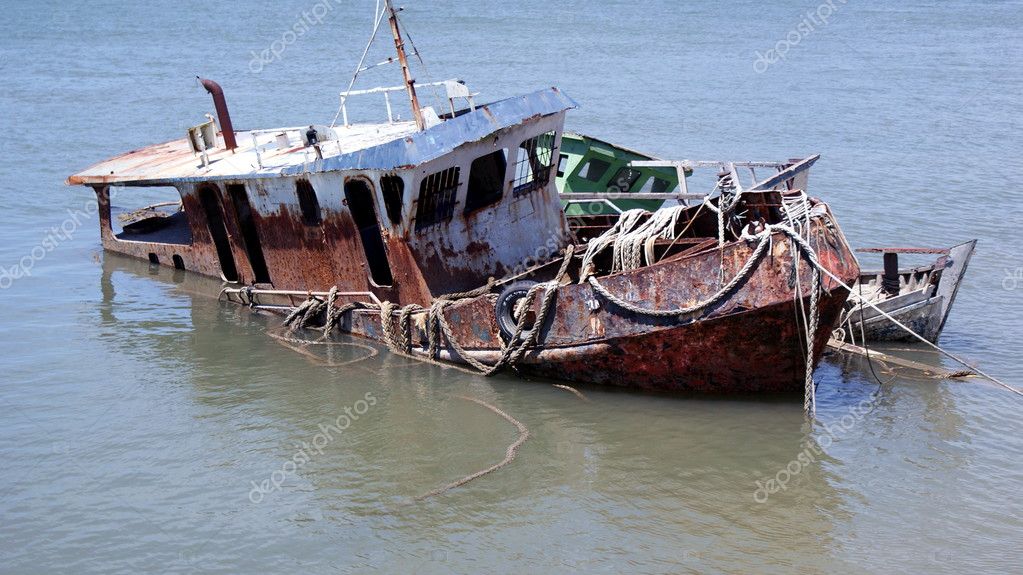 derelict boat rusting in water 1032x575