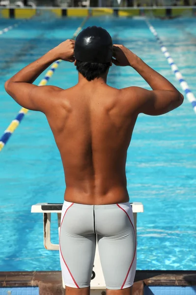Athlete swimmer in front of lap pool
