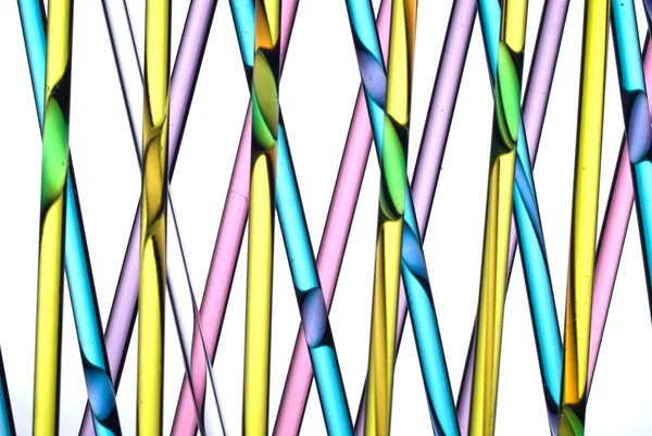 Close up of glass straws with coloured liquids