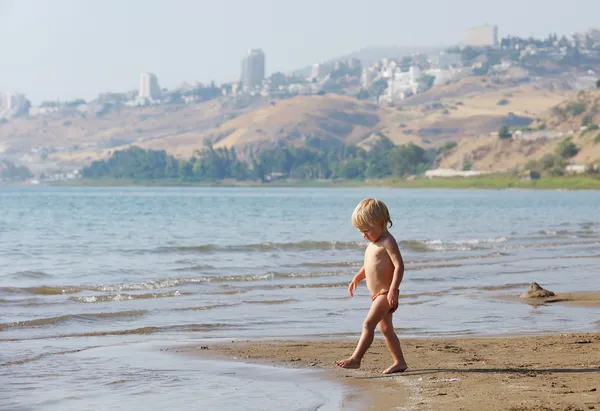 Niño en la orilla del lago Kinneret por la mañana —  Fotos de Stock