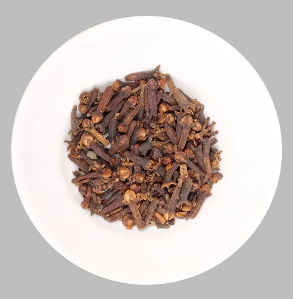 Heap of clove on white plate — Stock Photo, Image
