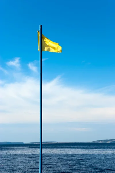 Bandeira amarela no céu — Fotografia de Stock