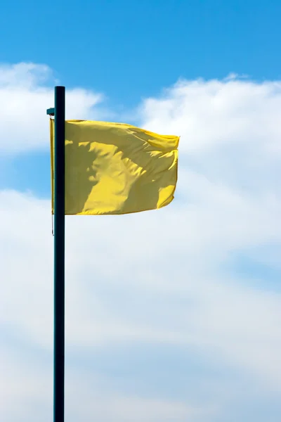 Желтый флаг в небе — стоковое фото