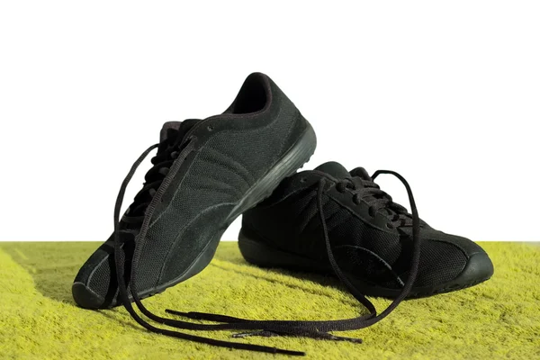 Sapatos pretos em um campo verde — Fotografia de Stock