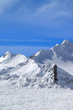 Snowboard against the snowy mountains clipart