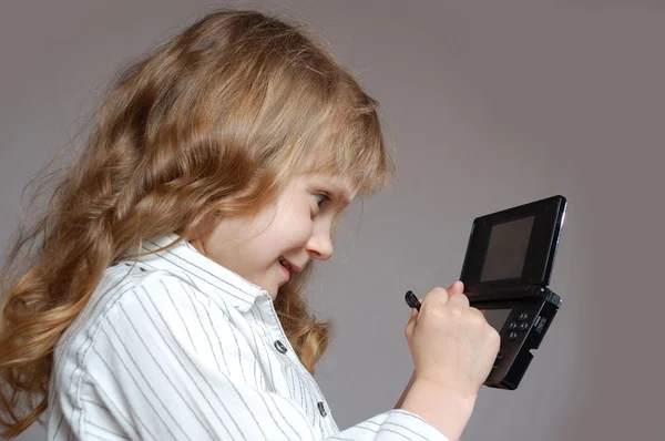 Girl playing with handheld game — Stock Photo, Image
