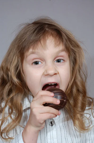 Küçük kız ısırma çikolatalı kurabiye. — Stok fotoğraf