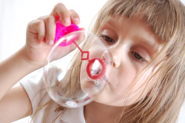 Klein meisje blaast grote zeepbel — Stockfoto