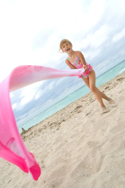 Ребенок играет с тряпкой на пляже — стоковое фото