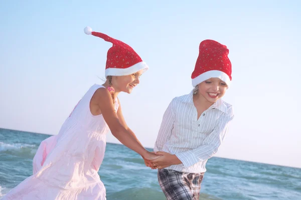 Weihnachtsmann Kinder am Strand — Stockfoto