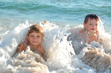 Children in waves on the beach clipart