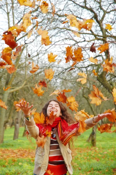 Woman throwing leaves — Stock Photo, Image