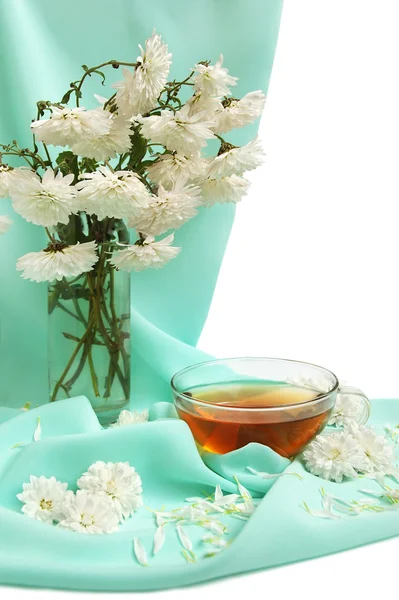Tasse de thé en verre et fleurs — Photo
