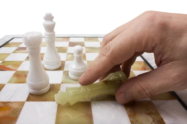 Hand poses a chess piece on the board