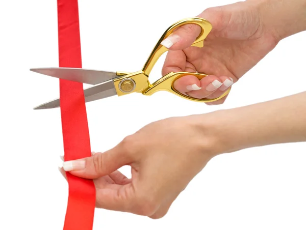Hands of woman with scissors and red line isolated — Stock Photo, Image