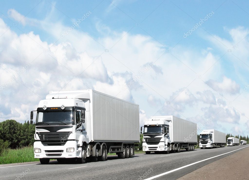Caravan of white trucks on highway