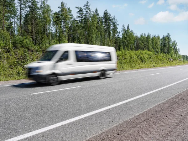 Branco mini ônibus de velocidade na estrada do país, borrão de movimento — Fotografia de Stock