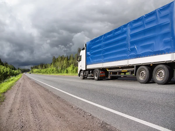 Truck on country highway and stormy clouds — Stock Photo, Image