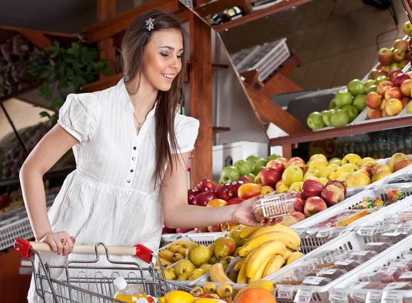 Mulher escolhe comida no supermercado — Fotografia de Stock