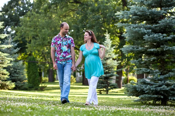Счастливая пара, взявшись за руки, гуляет в парке — стоковое фото