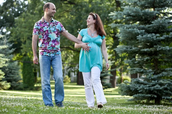Šťastný pár, s sepjatýma rukama procházka v parku — Stock fotografie