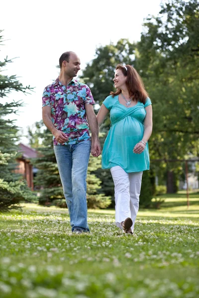 Boldog pár, miután csatlakozott kezét, séta a parkban — Stock Fotó