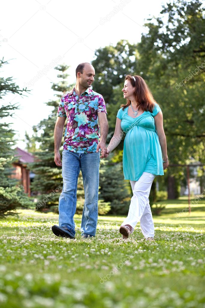 Happy couple, having joined hands walk in park