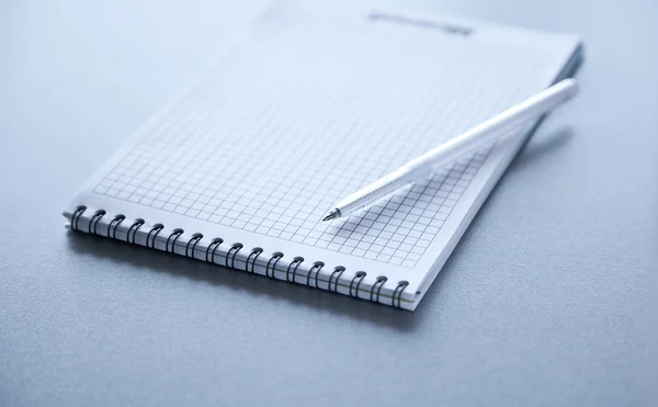 Pluma en el bloc de notas en la mesa de acero. gris tonificado — Foto de Stock