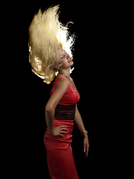 Heiße Blondine im roten Kleid schüttelt die Haare — Stockfoto